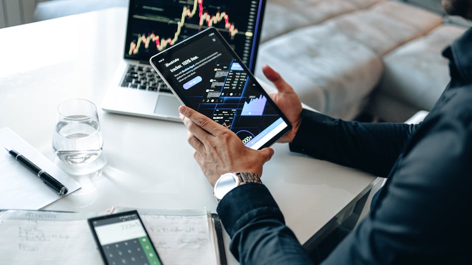 Osoba analyzující finanční grafy na notebooku v moderní kanceláři.